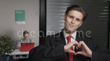 年轻的成功商人西装革履，展现了一种心灵的象征，一种爱的象征.. 男人在电脑上工作